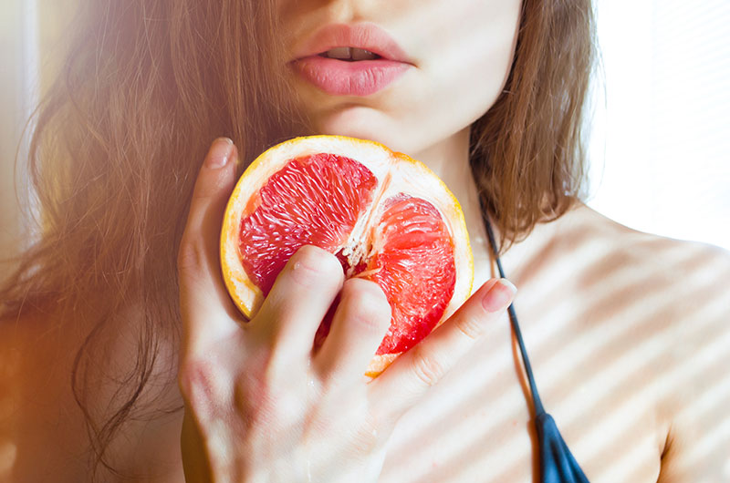 Frau imitiert Selbstbefriedigung an einer Grapefruit