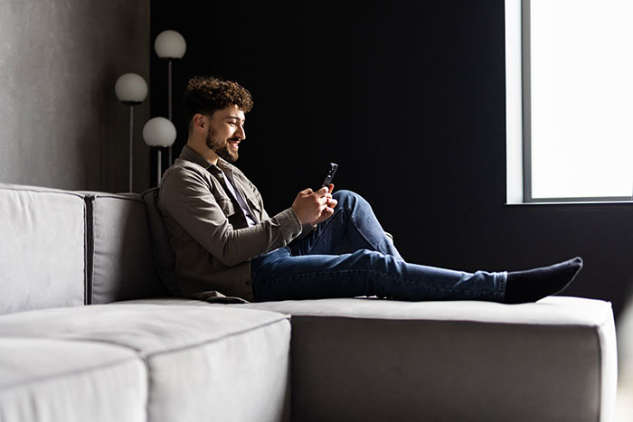 Glücklicher Mann chattet am Smartphone